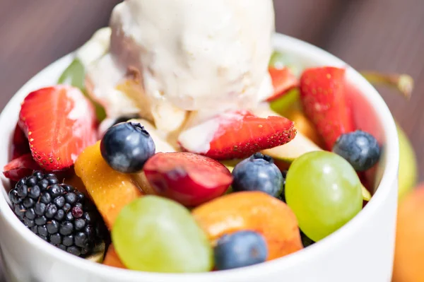 Primer plano del cuenco con ensalada de frutas frescas saludables con helado sobre fondo de madera . — Foto de Stock