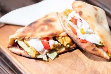 Ahşap bir tabak üzerinde ev yapımı baget ile Sağlıklı Izgara Tavuk Sandviç.