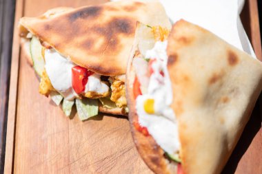 Ahşap bir tabak üzerinde ev yapımı baget ile Sağlıklı Izgara Tavuk Sandviç.