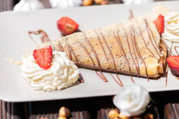 Läcker pannkaka med jordgubb och grädde på trä bakgrunden — Stockfoto