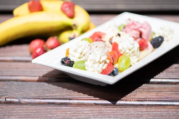 Ahşap arka plan üzerinde dondurma ile sağlıklı taze meyve salatası Tabak. — Stok fotoğraf