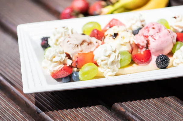 Ahşap arka plan üzerinde dondurma ile sağlıklı taze meyve salatası Tabak. — Stok fotoğraf