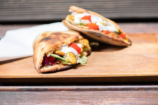 Ahşap bir tabak üzerinde ev yapımı baget ile Sağlıklı Izgara Tavuk Sandviç.