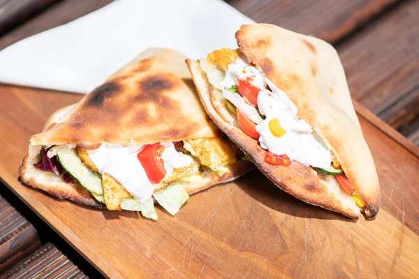 Ahşap bir tabak üzerinde ev yapımı baget ile Sağlıklı Izgara Tavuk Sandviç.