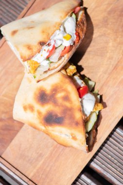 Ahşap bir tabak üzerinde ev yapımı baget ile Sağlıklı ızgara tavuk sandviç. Üstte görüntü.