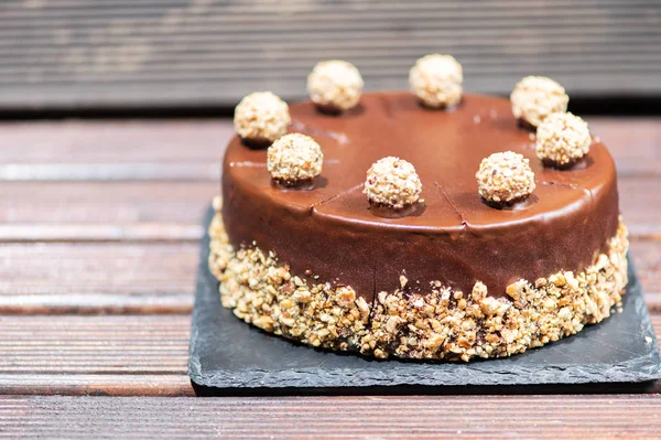 Chokladkaka på ett träbord med nötter — Stockfoto