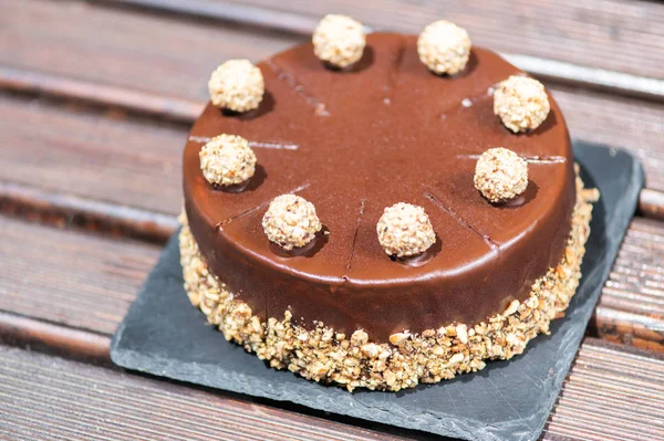 Chokladkaka på ett träbord med nötter — Stockfoto