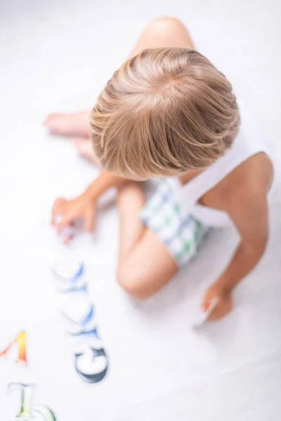 Hermoso niño aprendiendo cartas en el suelo en casa. Parte superior — Foto de Stock