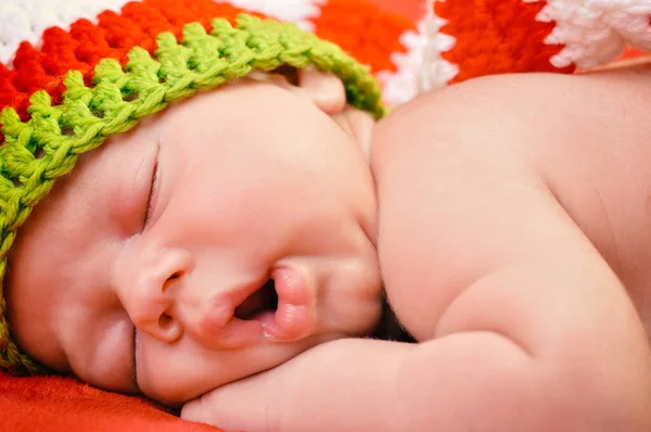 漂亮的男婴 戴着可爱的帽子 睡在柔软的红色毛毯上 安安静静 — 图库照片