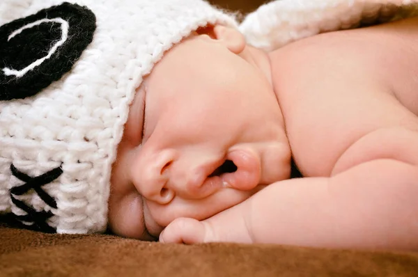 かわいい帽子をかぶった美しい新生児の男の子が柔らかい茶色の毛布の上に静かに眠る — ストック写真
