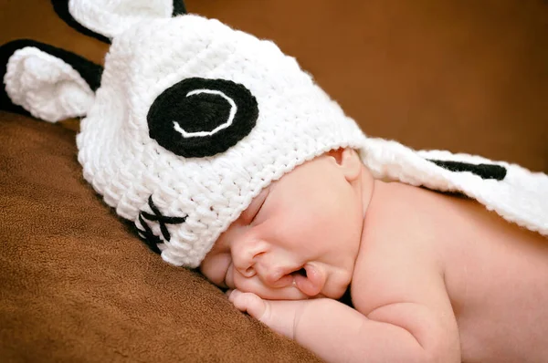かわいい帽子をかぶった美しい新生児の男の子が柔らかい茶色の毛布の上に静かに眠る — ストック写真