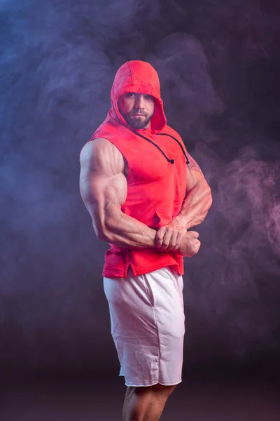 Δυνατός Μυώδης Άντρας Κουκούλα Που Ποζάρει Κόκκινη Μπλούζα Στούντιο Σουτ — Φωτογραφία Αρχείου