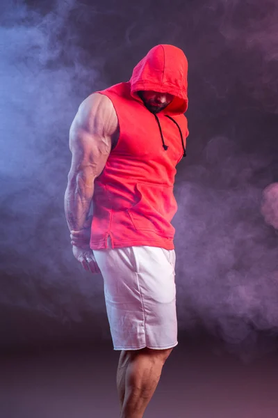 Мощный Мускулистый Мужчина Капюшоном Красной Толстовке Студийные Съемки Красным Синим — стоковое фото