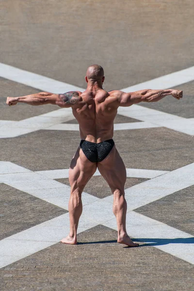 Kraftvoller Muskulöser Bodybuilder Höschen Der Park Posiert Rückenbeschwerden Arme Ausgestreckt — Stockfoto