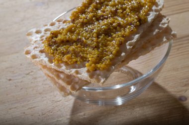 Cam bir kasenin üstünde hardal soslu çıtır ekmek.