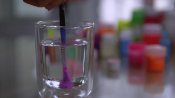Pinsel mit reinem Wasser ins Glas gespült — Stockvideo