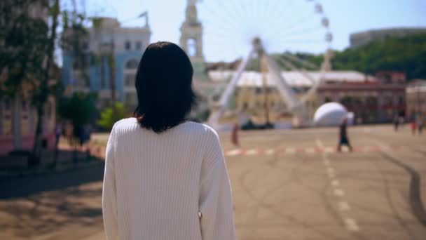 Vista posteriore di una donna che cammina attraverso il quartiere fieristico — Video Stock