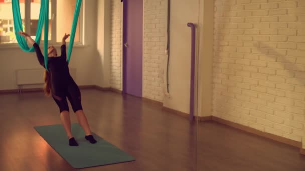 Señora estirando su cuerpo en la clase de yoga aéreo — Vídeos de Stock