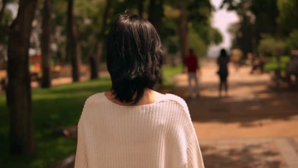 Vue arrière d'une femme marchant dans le parc — Video