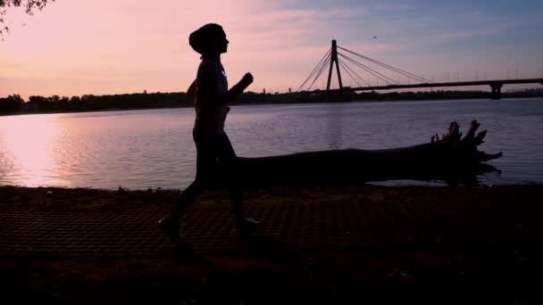 Silhouette female run near water — Stock Video