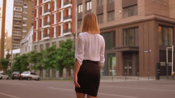 Blonde Geschäftsfrau spaziert durch die Stadt — Stockvideo