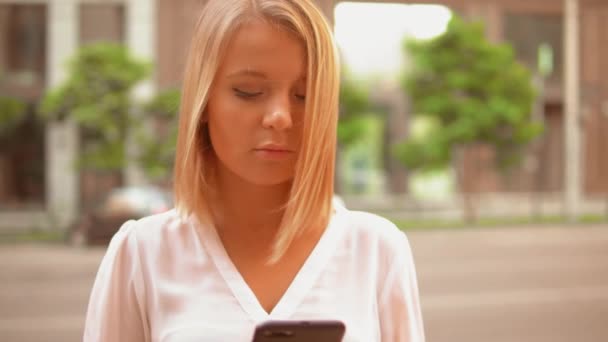 Mujer joven usando smartphone en la ciudad — Vídeos de Stock