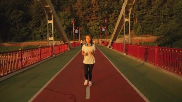 Señora está corriendo a lo largo de puente peatonal — Vídeo de stock