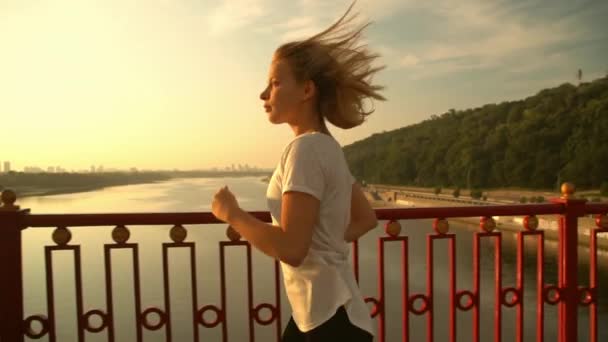 Женщина бежит по мосту — стоковое видео