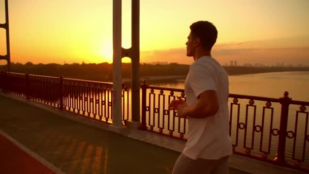 Man is jogging along the bridge — Stock Video