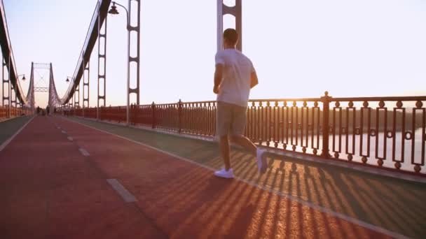Бегун бежит по пешеходному мосту — стоковое видео