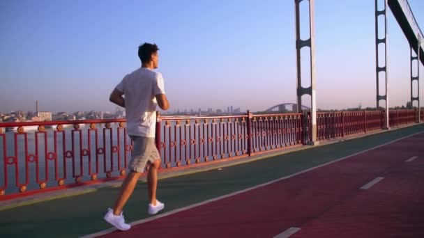 El hombre corre por el puente — Vídeos de Stock