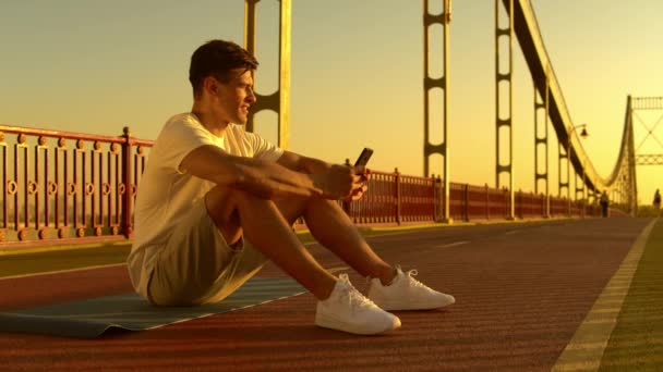 Cheerful guy texting on smartphone — Stock Video