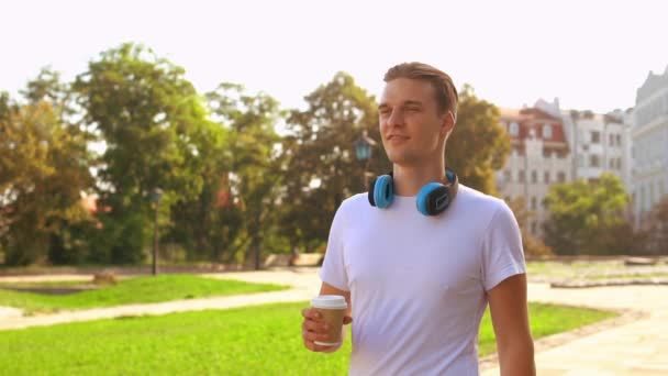 Cheerful male walks enjoy drink outdoors — Stock Video