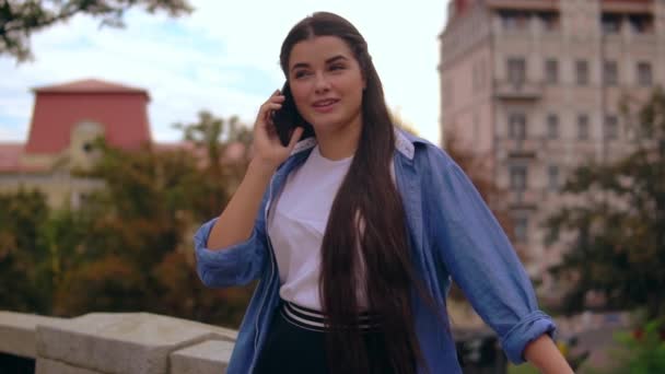 Портрет дівчини, що розмовляє мобільним на відкритому повітрі — стокове відео