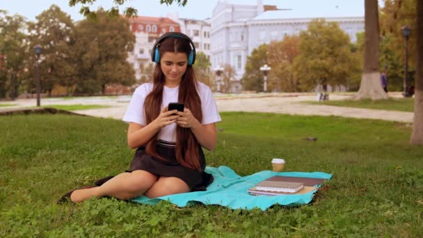 Chica escuchar canción descansando al aire libre — Vídeo de stock