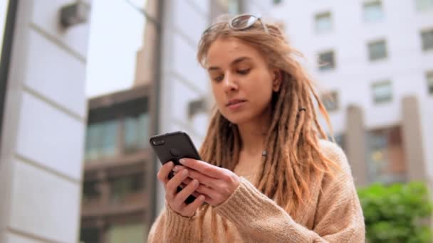 Mujer joven mensajes de texto SMS al aire libre — Vídeo de stock