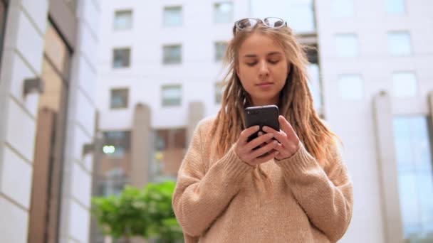年轻的女人与卷发短信短信站在街道市区慢动作 — 图库视频影像