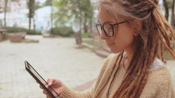 Menina feliz usar gadget ao ar livre — Vídeo de Stock