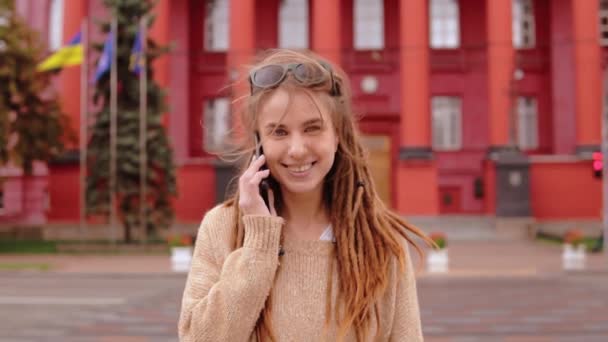 Young woman with dreadlocks talking by phone — Stock Video