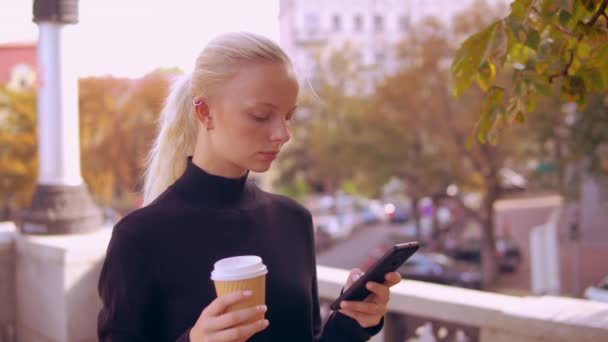 Portret blonde gebruik telefoon in de stad — Stockvideo