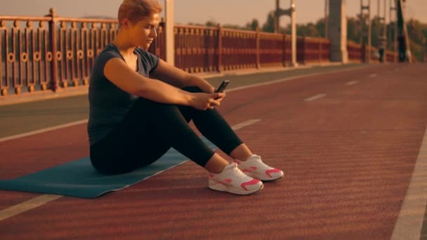 Caucasien jogger en utilisant mobile à l'extérieur — Video