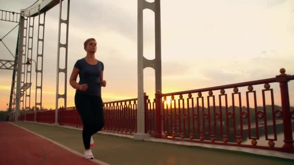 Jogger femelle courir sur le pont — Video