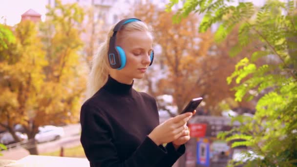 Retrato chica con auriculares en la ciudad — Vídeos de Stock