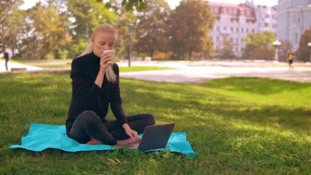 Blonde girl use computer outdoors — Stock Video