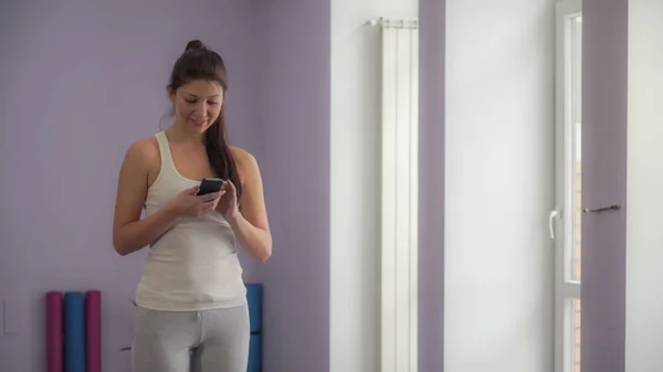 Vrouw in de sportschool met de telefoon — Stockfoto