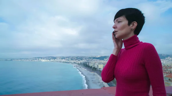 Woman tourist calling on the smartphone stand on the  observation deck.