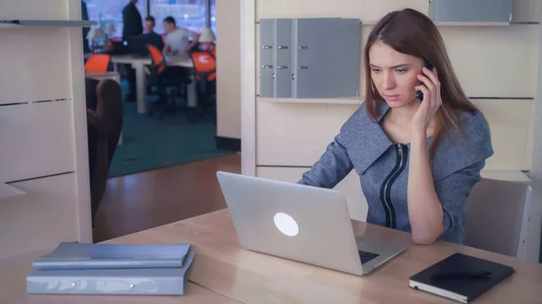 Multitasking zakenvrouw in de werkplaats. — Stockfoto