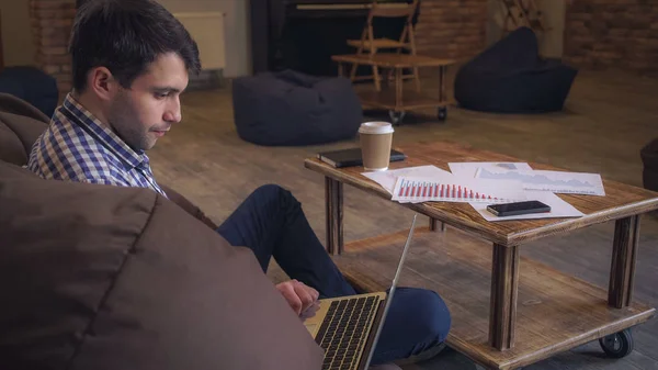 L'homme assis au repos, regardant le moniteur et buvant du café . — Photo