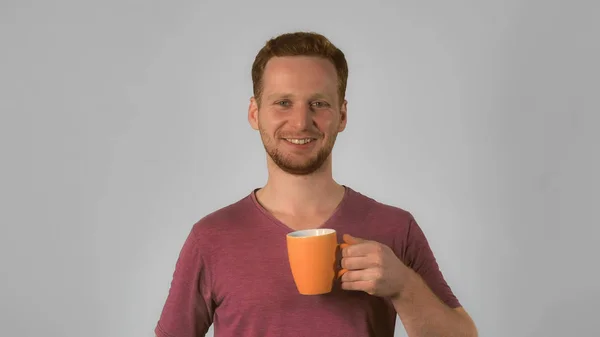 Étudiant gingembre tient tasse avec sourire heureux — Photo