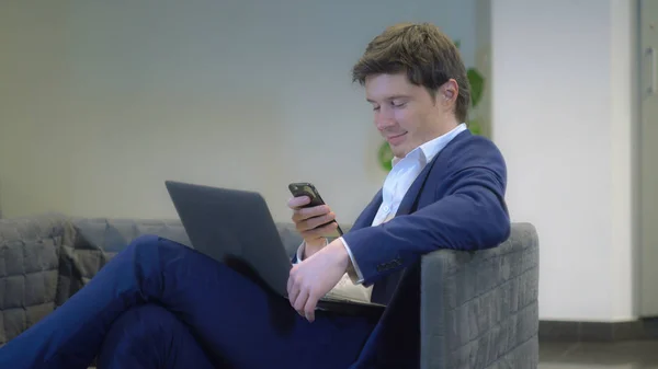 Молодий чоловік розслабляється використовує мобільний телефон — стокове фото